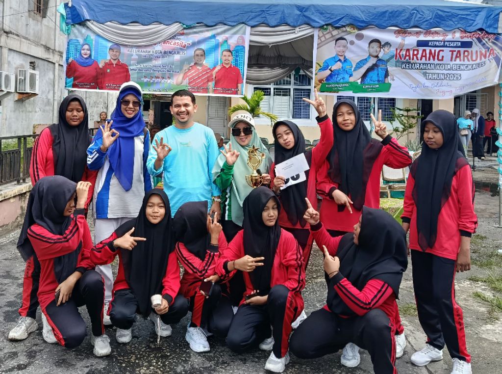 Teks Foto: Para guru pembimbing, Putra Farinsyah, S.Sos dan Anggi Savhira, A.Md.Kom, berpose bersama sepuluh siswi MTs YPPI Bengkalis usai berhasil meraih Juara II pada Lomba Gerak Jalan Kampung Pancasila. Kekompakan, disiplin, dan kerja keras yang ditunjukkan selama latihan menjadi kunci keberhasilan tim ini dalam menorehkan prestasi yang membanggakan.