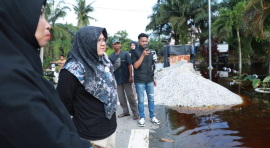 Teks foto: Bupati Siak, Afni Zulkifli, meninjau langsung lokasi banjir di Kampung Mengkapan, Kecamatan Sungai Apit, Kamis (18/12/2025). Genangan setinggi lutut orang dewasa merendam permukiman dan fasilitas pendidikan, memaksa warga menyesuaikan aktivitas sehari-hari.